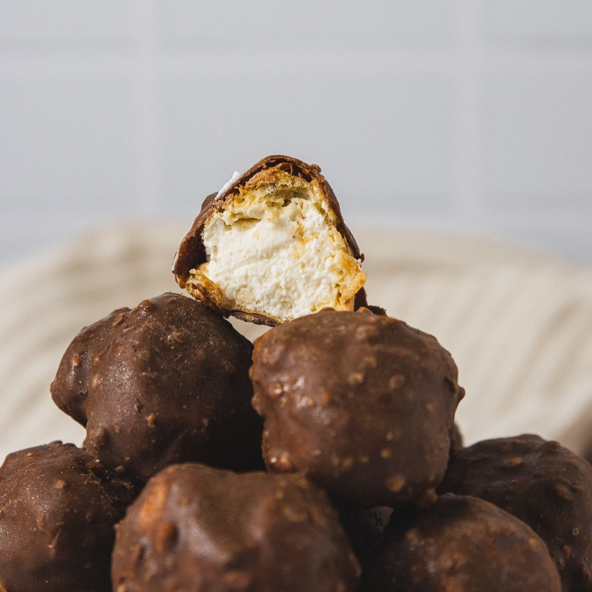 Profiteroles Rellenos de Crema Inglesa Cubiertos de Chocolate y Avellanas 30u